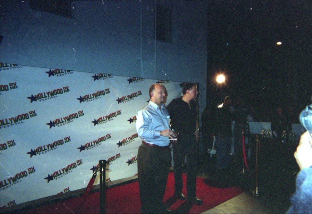 Two men on the red carpet in front of a Hollywood HD Festival step-and-repeat banner.